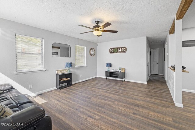 living area with ceiling fan, baseboards, wood finished floors, and a textured ceiling