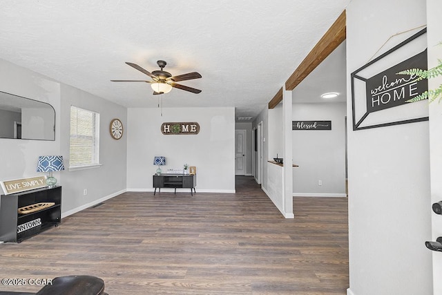 entryway with a textured ceiling, baseboards, a ceiling fan, and wood finished floors