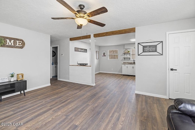 living room featuring dark wood-style floors, baseboards, a ceiling fan, and a textured ceiling