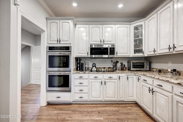 1000 Oakmont Dr, Joplin, MO 64804 - kitchen featuring a toaster, light wood-style flooring, light stone counters, and appliances with stainless steel finishes