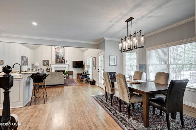 1000 Oakmont Dr, Joplin, MO 64804 - dining area with light wood-style floors, a fireplace, ornamental molding, and a wealth of natural light