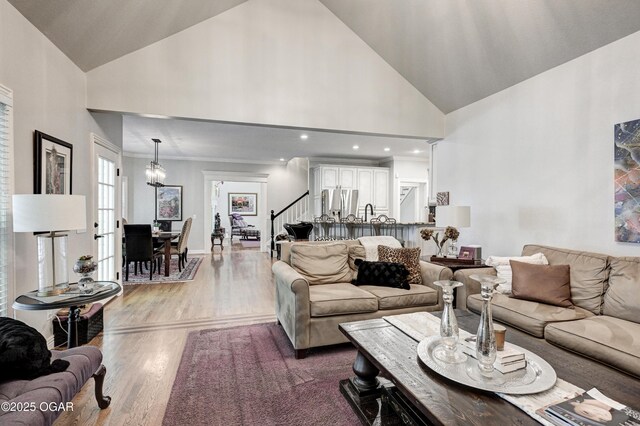 1000 Oakmont Dr, Joplin, MO 64804 - living room featuring a chandelier, wood finished floors, high vaulted ceiling, and stairs