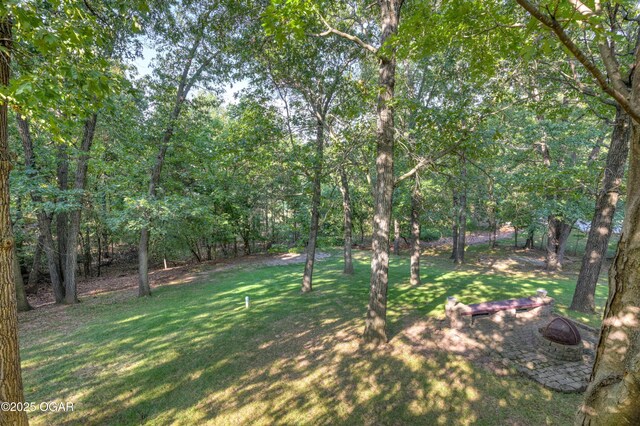 1000 Oakmont Dr, Joplin, MO 64804 - view of yard featuring a wooded view and a fire pit