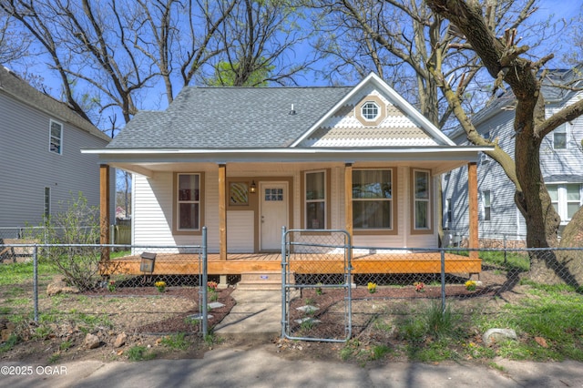 view of front of home with a porch, fence private yard, and roof with shingles