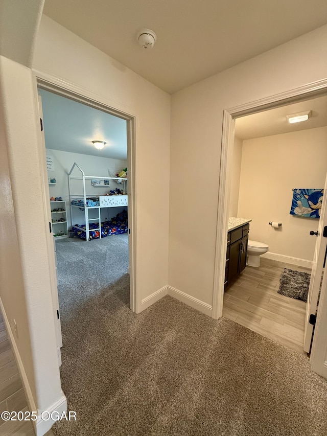 corridor with baseboards and carpet flooring