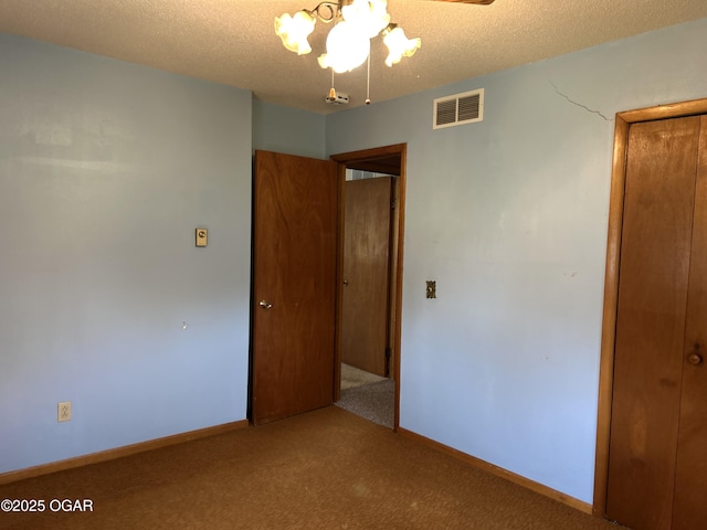 unfurnished bedroom featuring visible vents, baseboards, carpet flooring, and a textured ceiling