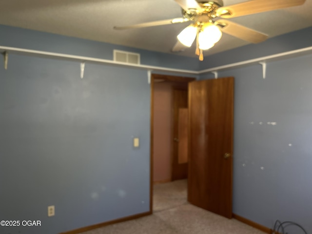 carpeted empty room featuring ceiling fan and visible vents