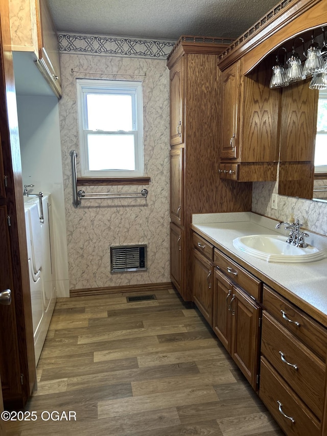 bathroom featuring vanity, visible vents, baseboards, and wood finished floors