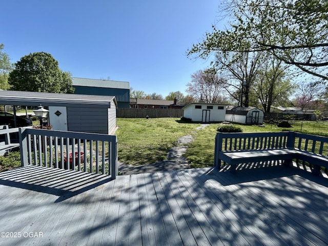 wooden terrace with a yard, a fenced backyard, an outdoor structure, and a storage unit