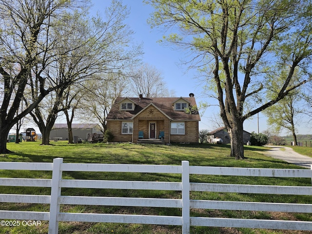 view of front of property with a fenced front yard, driveway, a chimney, and a front yard