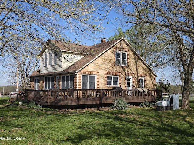 back of property with a yard, a wooden deck, and a chimney