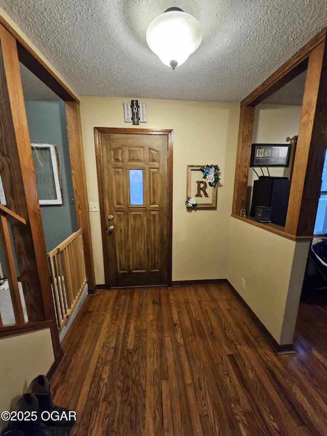 entrance foyer featuring dark wood finished floors, a textured ceiling, and baseboards