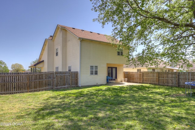 2706 E 26th St, Joplin, MO 64804 - back of property with a yard, a trampoline, a chimney, a fenced backyard, and a patio