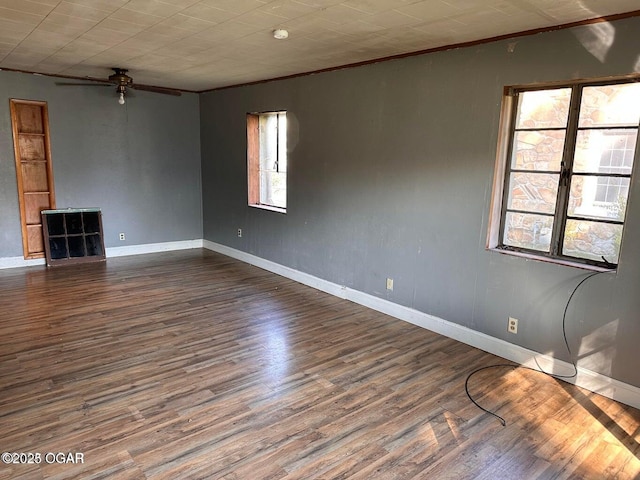 unfurnished room with a ceiling fan, wood finished floors, baseboards, and ornamental molding