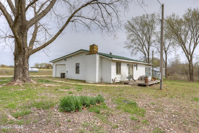 241 SE 40th Rd, Lamar, MO 64759 - back of house featuring a chimney, a wooden deck, a garage, and central AC