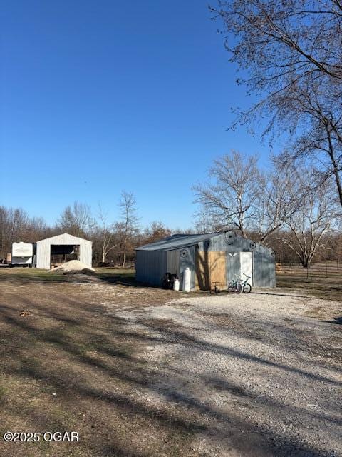 241 SE 40th Rd, Lamar, MO 64759 - view of yard featuring an outbuilding, an outdoor structure, a garage, and gravel driveway
