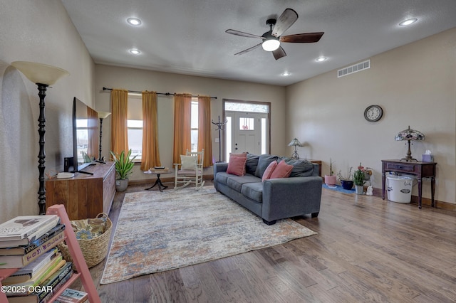 living area with a ceiling fan, visible vents, recessed lighting, wood finished floors, and baseboards