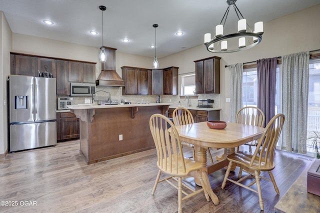 dining room with light wood-style floors, an inviting chandelier, and recessed lighting