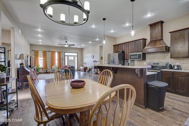 dining space featuring light wood-style flooring, a ceiling fan, and recessed lighting