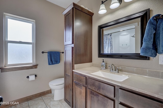 full bath featuring toilet, vanity, and baseboards