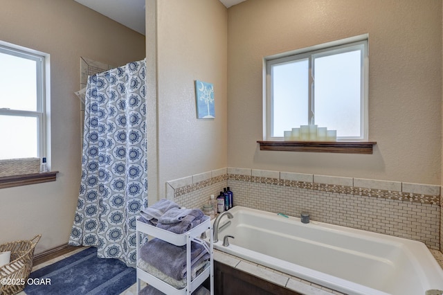 bathroom featuring a bath, curtained shower, and a wealth of natural light