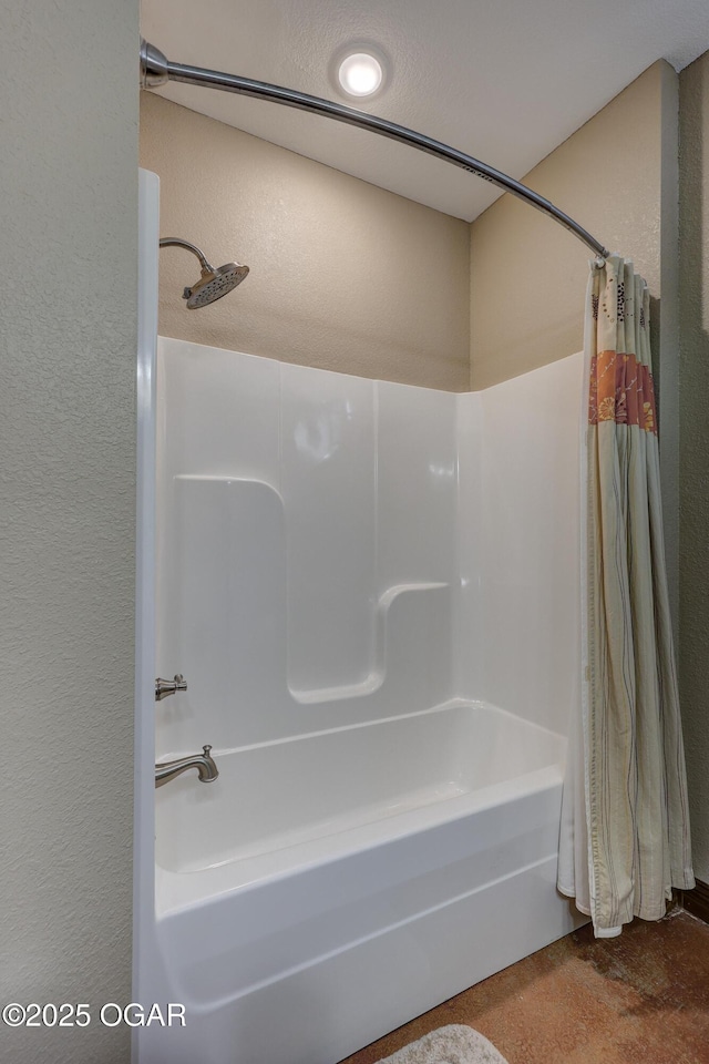 full bath with shower / bath combo and a textured wall