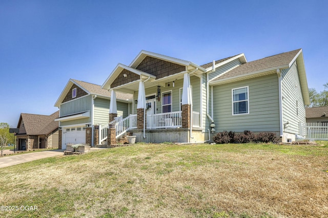craftsman-style home with fence, covered porch, a front yard, and concrete driveway