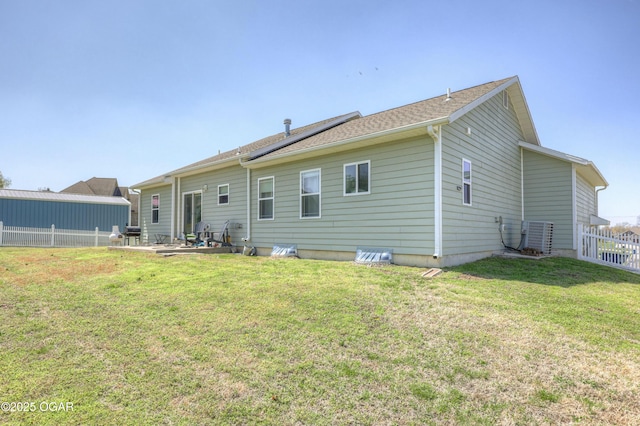 rear view of house featuring a patio area, central air condition unit, fence, and a lawn