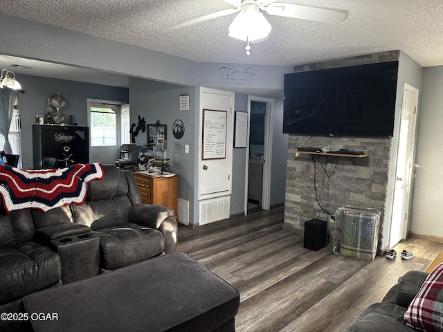 2027 P St SW, Miami, OK 74354 - living area featuring a textured ceiling, wood finished floors, a ceiling fan, and visible vents