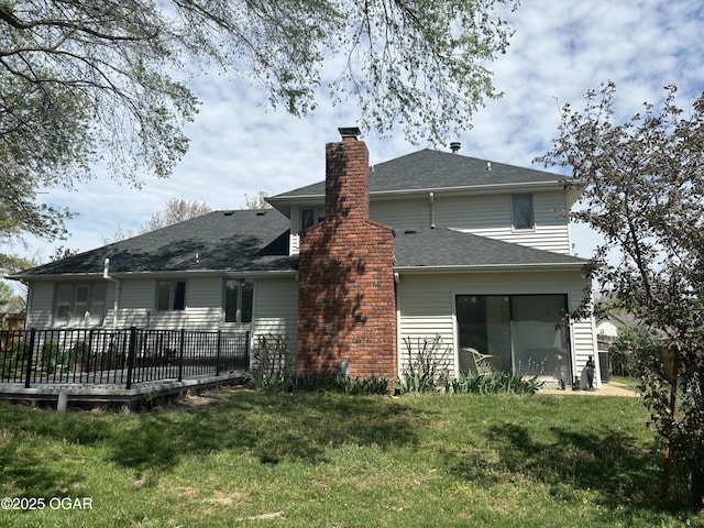back of property with a wooden deck, a chimney, and a lawn