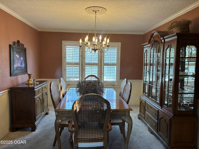 dining space with a chandelier, a textured ceiling, light colored carpet, and crown molding