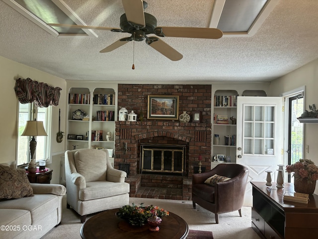 living area featuring a textured ceiling, ceiling fan, a fireplace, and carpet floors