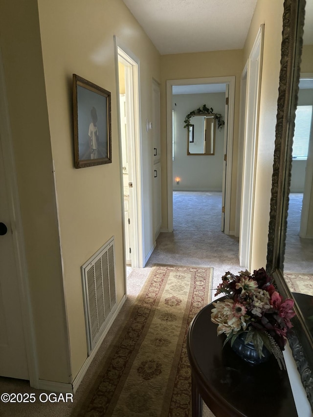 corridor with visible vents and carpet flooring