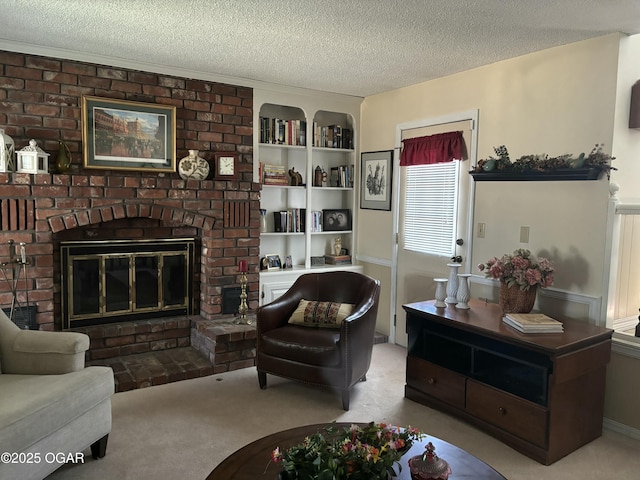 living area featuring a textured ceiling, a fireplace, built in shelves, and carpet floors