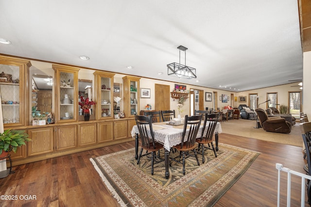 dining area with dark wood-type flooring, recessed lighting, and crown molding