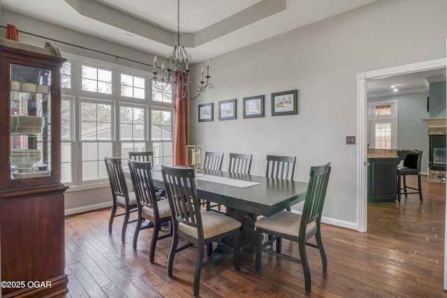 dining space featuring dark wood-style floors, an inviting chandelier, and plenty of natural light