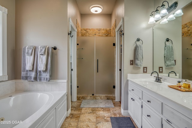 bathroom featuring a stall shower, a garden tub, stone finish floor, and vanity