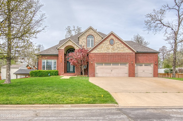 traditional-style house with driveway, a front yard, fence, brick siding, and a garage
