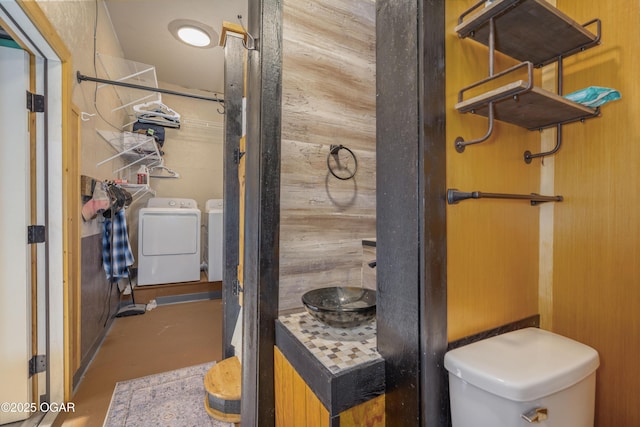 17881 Goldfinch Rd, Neosho, MO 64850 - bathroom featuring finished concrete floors, washing machine and clothes dryer, and toilet