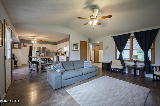 living area featuring lofted ceiling, a textured ceiling, and ceiling fan