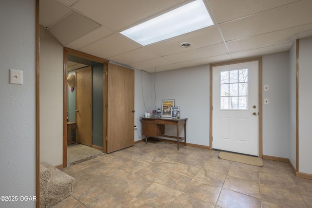 foyer featuring baseboards, visible vents, and a paneled ceiling