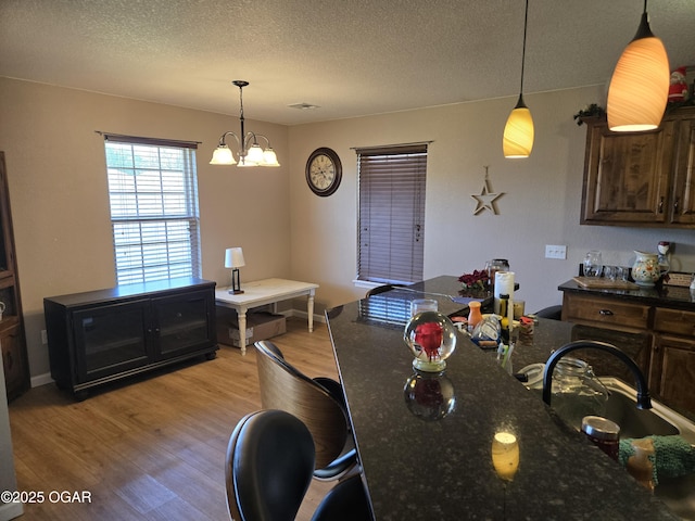 2798 Neosho Heights Ave, Neosho, MO 64850 - dining room featuring light wood finished floors, visible vents, a textured ceiling, and a chandelier