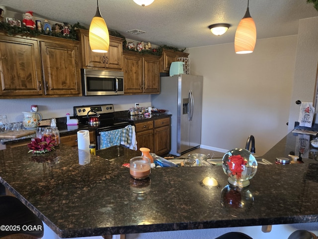 2798 Neosho Heights Ave, Neosho, MO 64850 - kitchen featuring a breakfast bar area, dark stone counters, appliances with stainless steel finishes, and hanging light fixtures