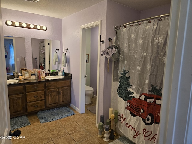 2798 Neosho Heights Ave, Neosho, MO 64850 - bathroom with a sink, a textured wall, double vanity, toilet, and tile patterned flooring
