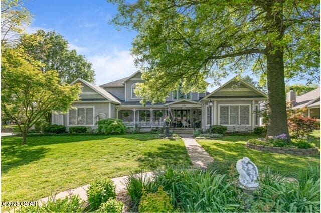 1529 S Grand Ave, Carthage, MO 64836 - back of property with covered porch and a yard