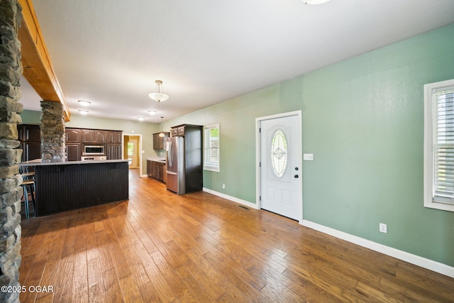 24336 S Hilltop Dr, Afton, OK 74331 - kitchen with a kitchen breakfast bar, dark brown cabinets, a peninsula, stainless steel appliances, and hardwood / wood-style floors