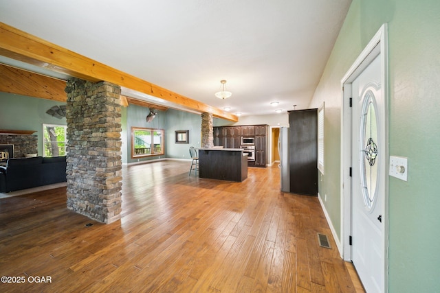 24336 S Hilltop Dr, Afton, OK 74331 - kitchen featuring a fireplace, open floor plan, a kitchen breakfast bar, ornate columns, and stainless steel appliances