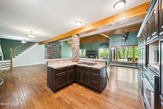 24336 S Hilltop Dr, Afton, OK 74331 - kitchen with dark brown cabinetry, a fireplace, light countertops, stainless steel appliances, and open floor plan