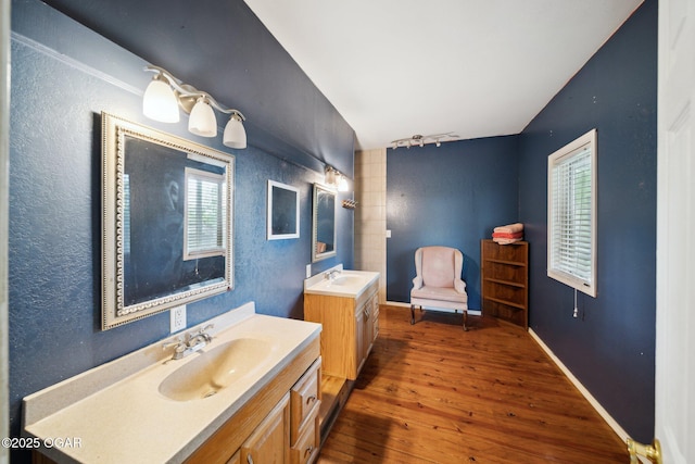 24336 S Hilltop Dr, Afton, OK 74331 - bathroom with rail lighting, two vanities, a sink, and wood finished floors