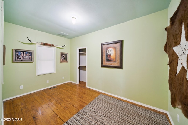 24336 S Hilltop Dr, Afton, OK 74331 - unfurnished bedroom with visible vents, baseboards, a walk in closet, and wood-type flooring